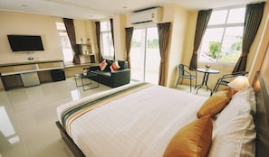 Una habitación de hotel con una cama grande, un escritorio, una silla y un televisor.