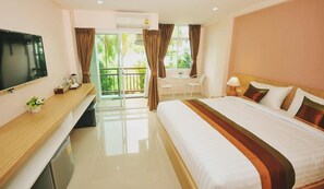 A hotel room with a bed, a TV, a desk, a chair, and a balcony with curtains. - Sukkhamas Pirom Hotel (Nakhon Ratchasima)