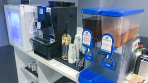 A coffee machine and a beverage dispenser in a hotel setting. - Lucas Hotel (Changwon)
