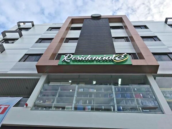 Un immeuble avec une enseigne verte portant l’inscription « Résidentiel » sur la façade.