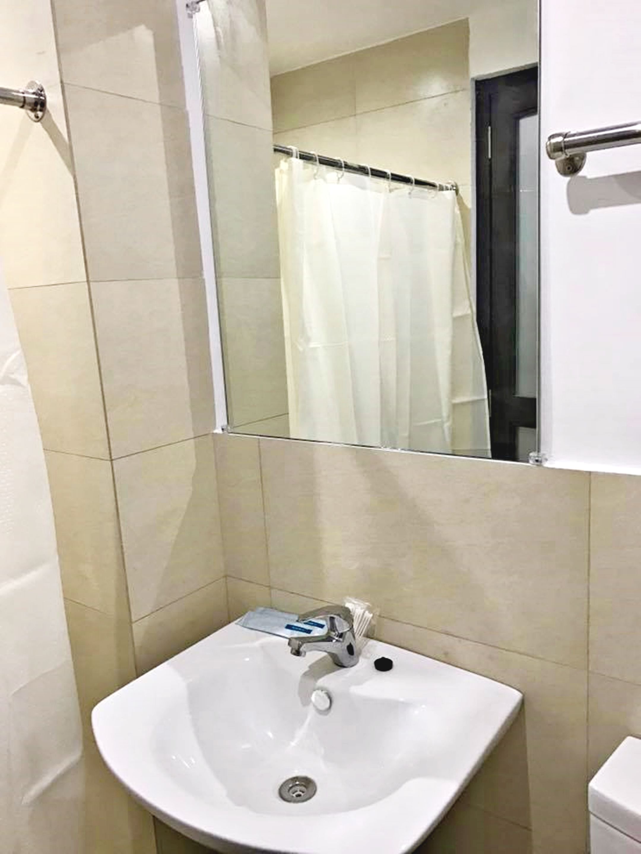 A bathroom with a white sink, a mirror, and a shower curtain.