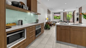 A modern kitchen with wooden cabinets, stainless steel appliances, and a central island with a sink.
