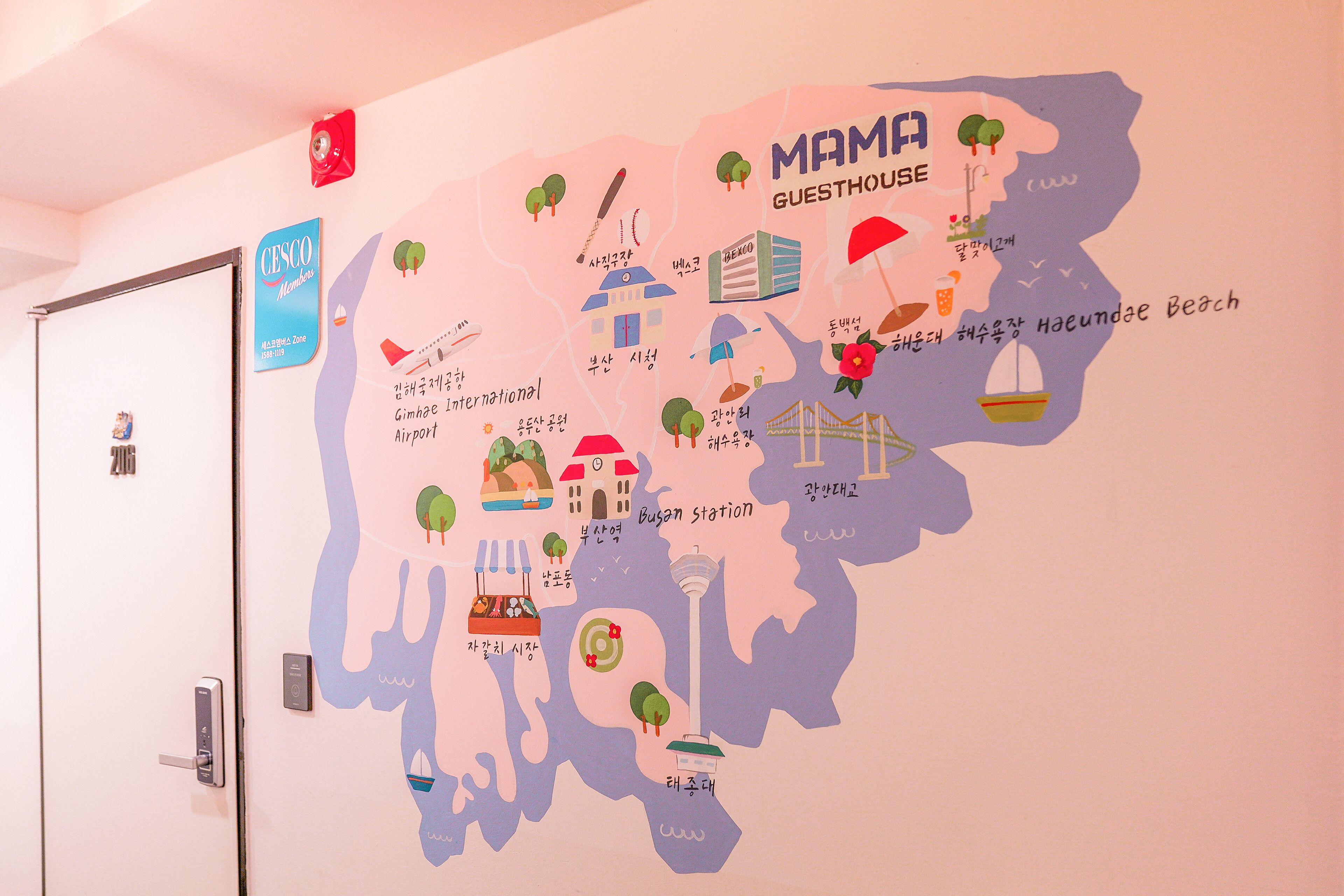 Un mapa mural con ilustraciones de puntos de referencia y servicios como una casa de huéspedes, aeropuerto y playa.