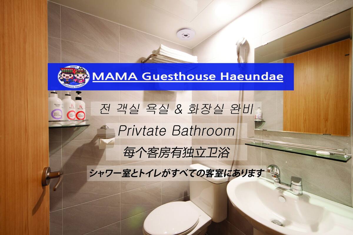A private bathroom with a toilet, sink, and glass shelf. There are toiletries on the shelf.