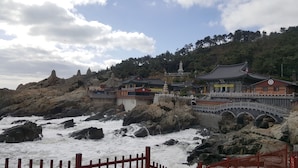 Un ensemble de temples traditionnels comprenant plusieurs bâtiments, un pont et un terrain rocheux.