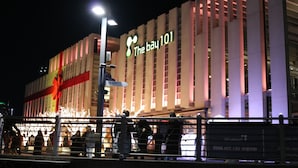 Un bâtiment sur lequel on peut voir une enseigne bien visible indiquant « The Bay 101 », ainsi qu’un grand ruban rouge décoratif.