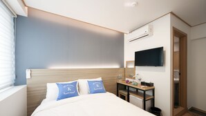 Une chambre d’hôtel avec un lit, un bureau, une télévision et une salle de bain.
