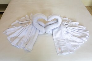 A bed with a heart-shaped towel arrangement on the bedspread. - Batuque Town Villa (Batu)