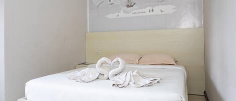 Una cama bien hecha con un mapa del mundo en la pared de arriba.