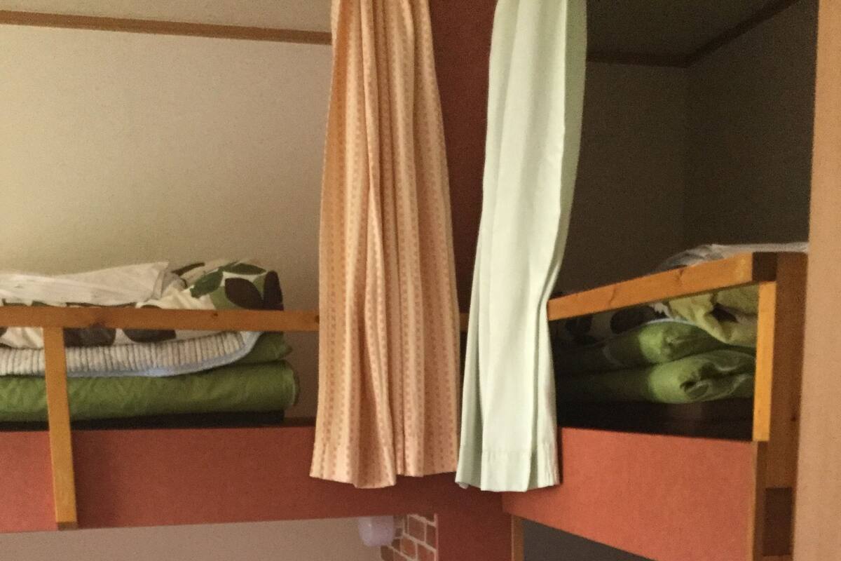 Un dormitorio con literas, una pared de ladrillo y un suelo a cuadros.