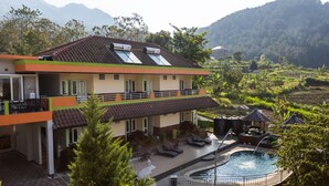 A two-story house with a swimming pool, surrounded by lush greenery and mountains. - Villa Panderman Indah (Batu)