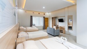 A hotel room with three beds, a sofa, a TV, and a mirror. - Villa Panderman Indah (Batu)