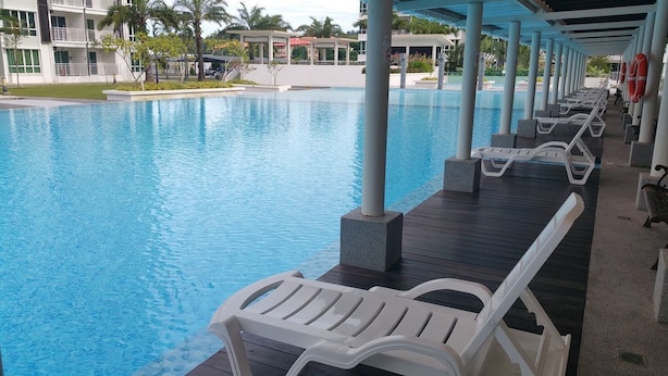 A swimming pool with lounge chairs and a covered deck area. - Homestay Signature Suite (Sandakan)