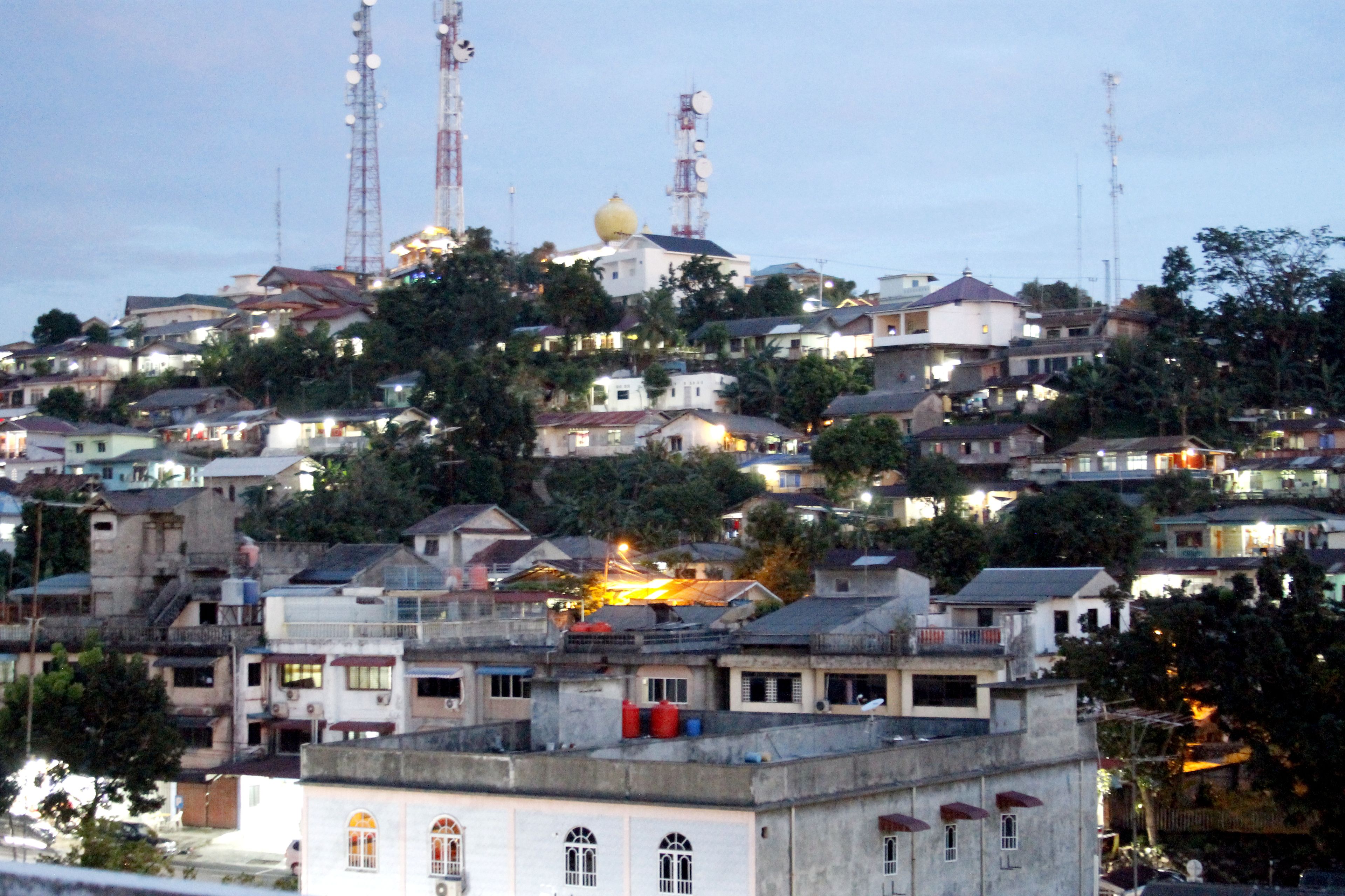 A densely packed urban area with multiple buildings, some with visible balconies and rooftops.