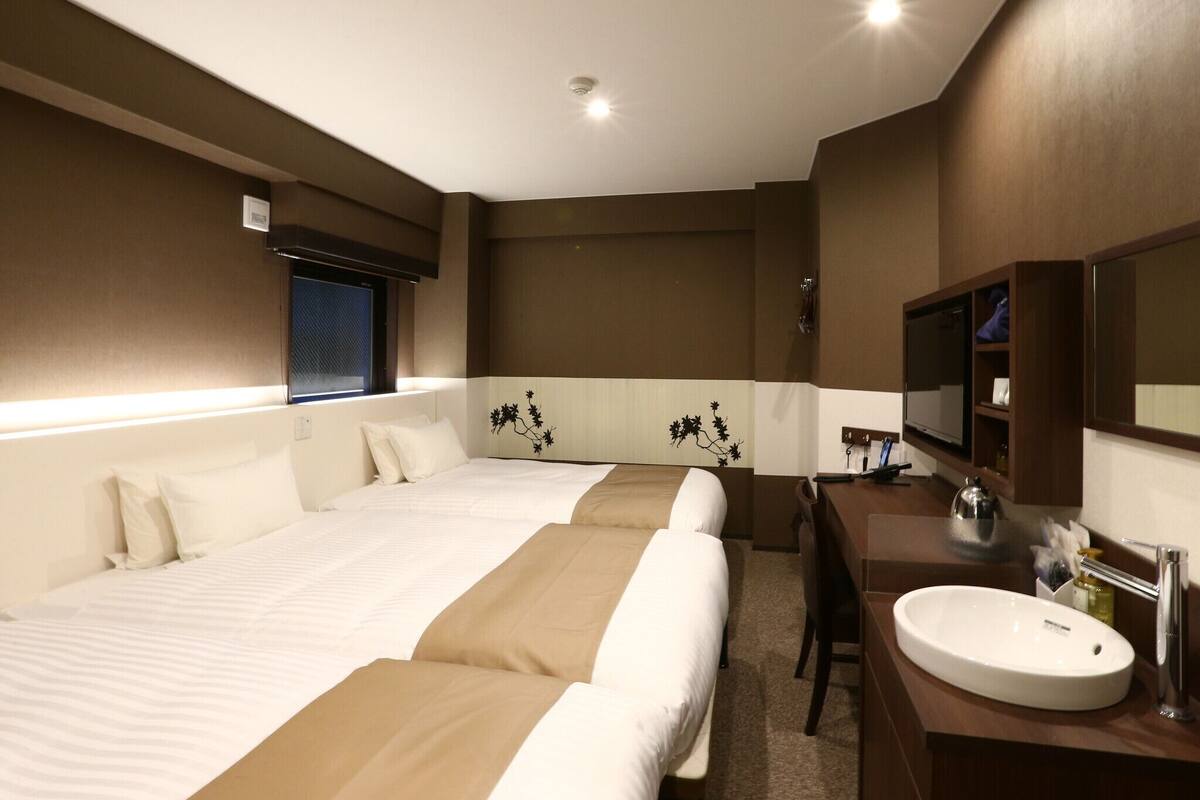 Une chambre d’hôtel avec un grand lit, un bureau doté d’un lavabo et un miroir.