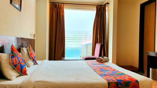 Una habitación de hotel con una cama, una silla y vistas al exterior.