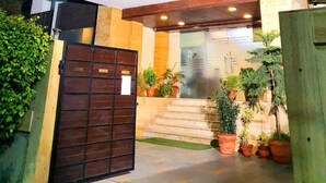 Un edificio moderno de dos pisos con techo plano, ventanas amplias y entrada protegida por una reja.