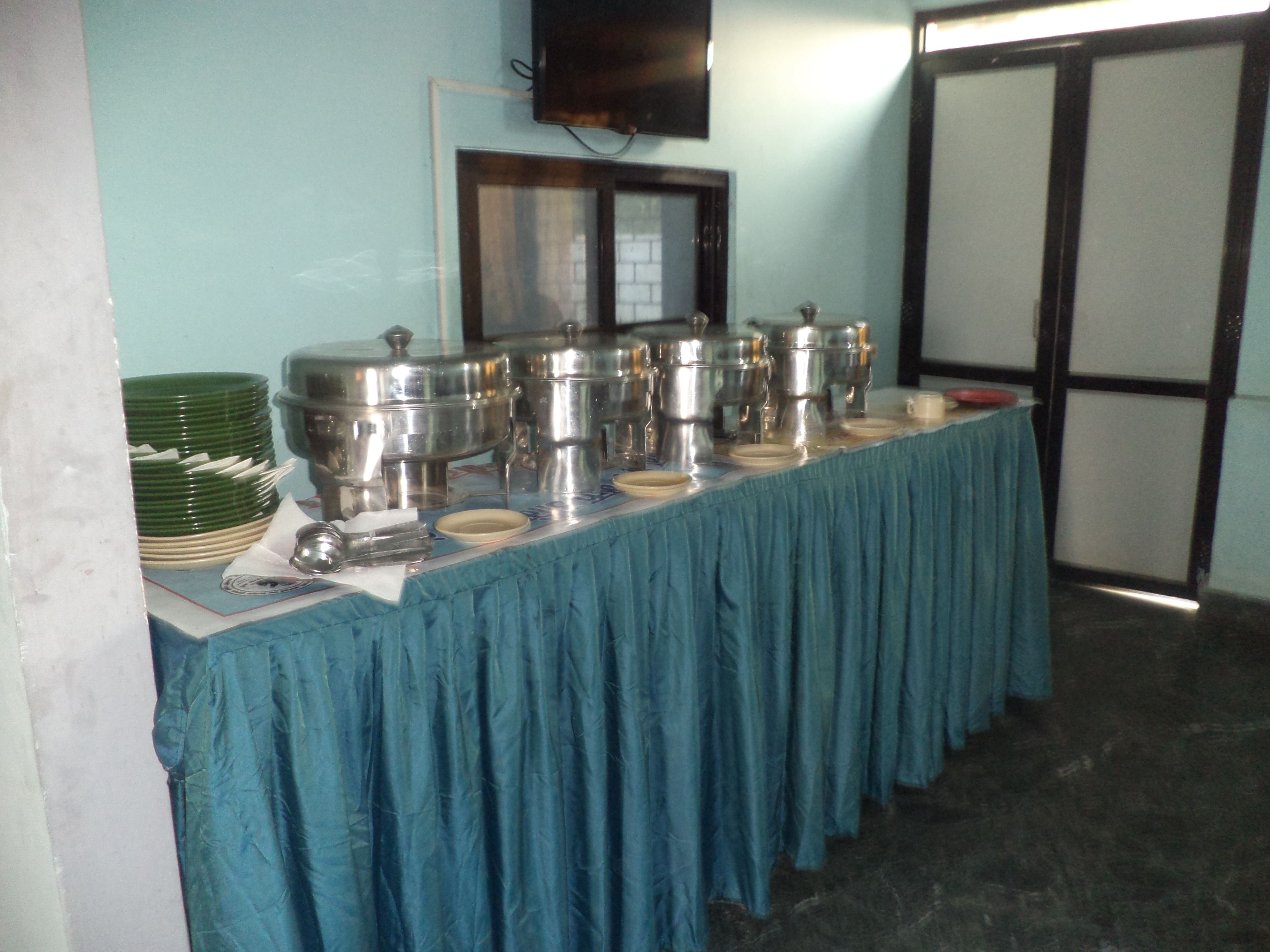 A buffet table with multiple serving dishes and a blue tablecloth.