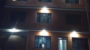 Un edificio a più piani con finestre illuminate e un ingresso ben visibile.