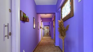 A hallway with purple walls and a patterned carpet.
