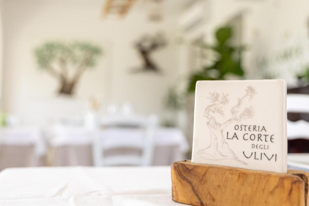 A book titled 'Osteria La Corte degli Ulivi' on a wooden stand.