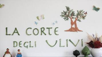 Paredes com o texto 'LA CORTEGLI VLIVI' e uma ilustração de uma árvore.