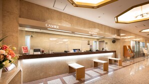 A hotel reception area with a marble counter, a reception desk, and a clock on the wall. - Meitetsu Komaki Hotel (Komaki)