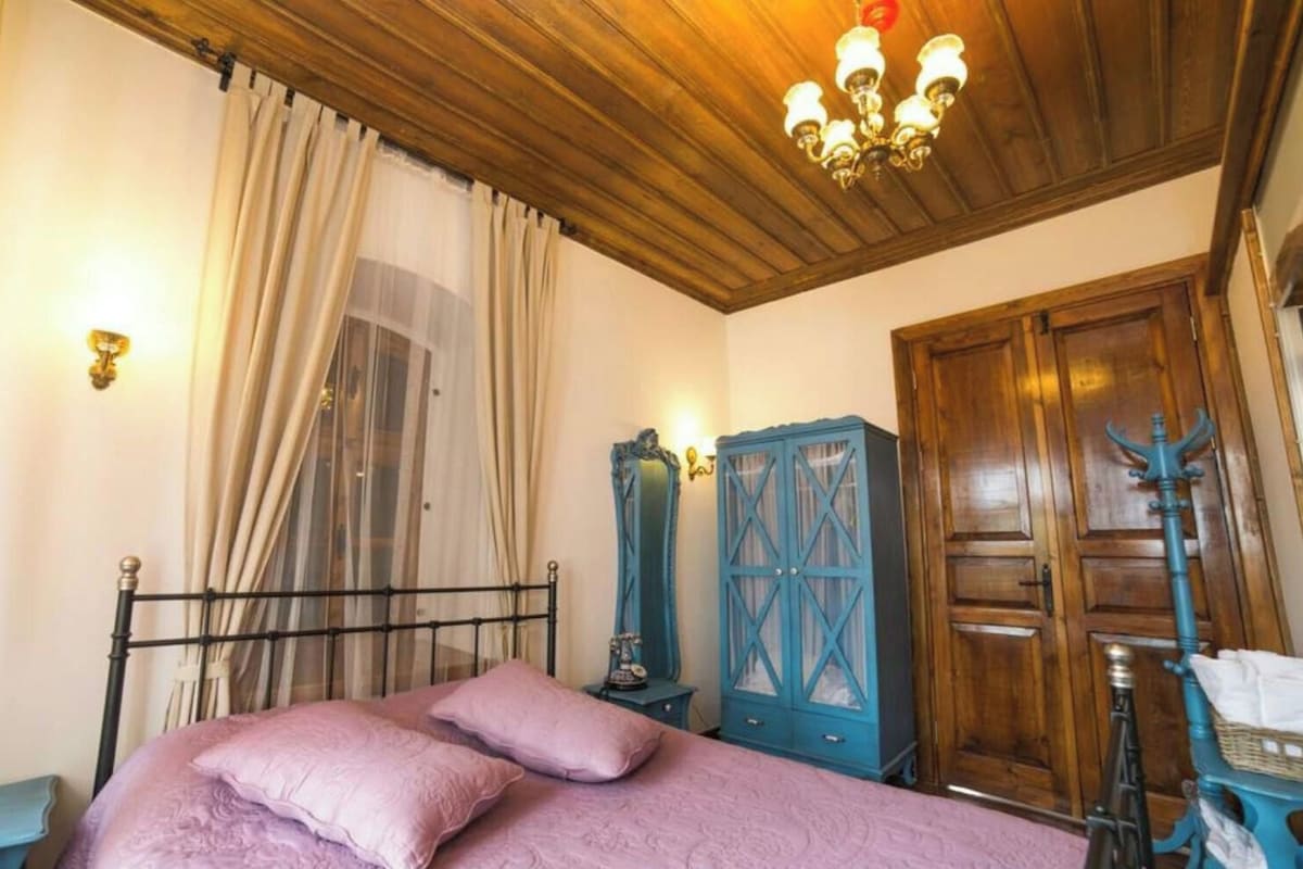 Un dormitorio con cama, armario, espejo y techo de madera.