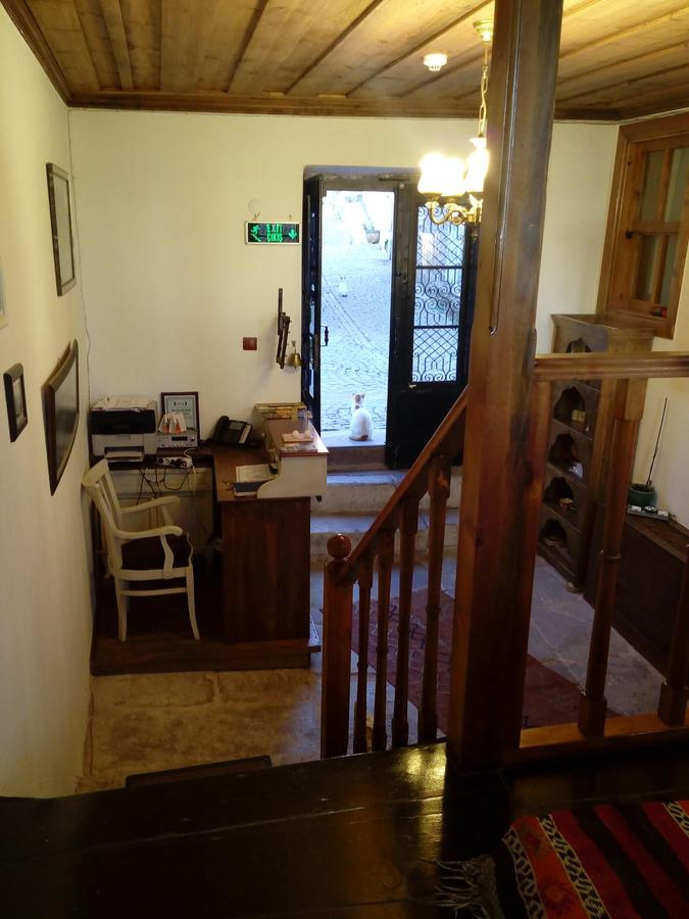 Ein Zimmer mit Schreibtisch, Stuhl und einer Treppe zu einer Tür.