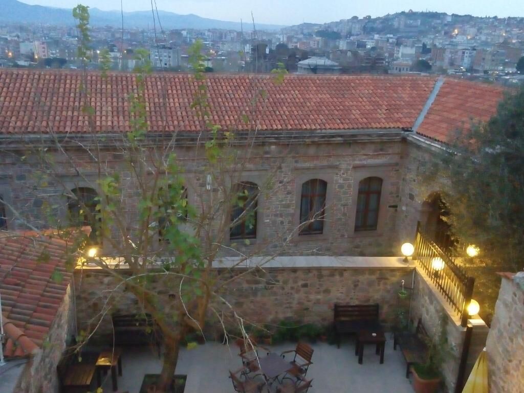 Un patio con paredes de piedra, techo de tejas y mobiliario para exteriores.
