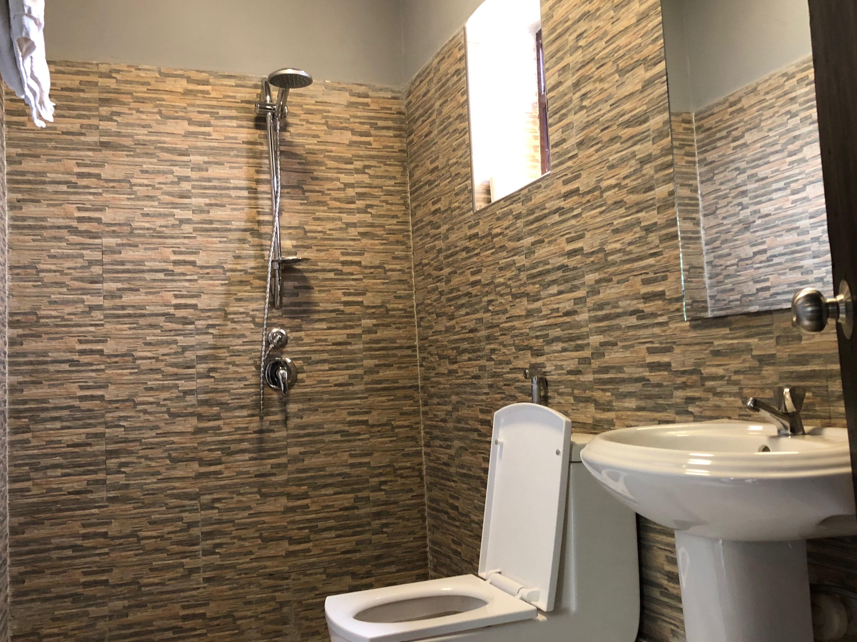 A bathroom with a shower, toilet, and sink.
