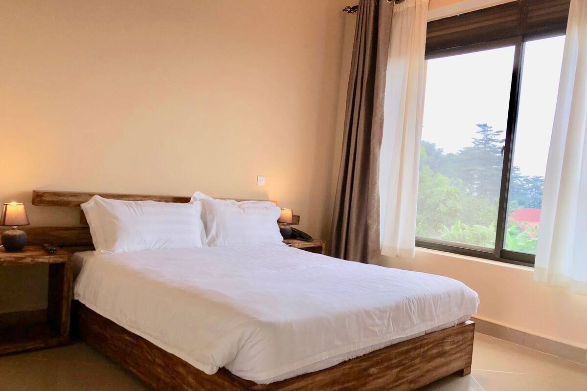 A bed with white bedding, wooden headboard, and nightstands with lamps.