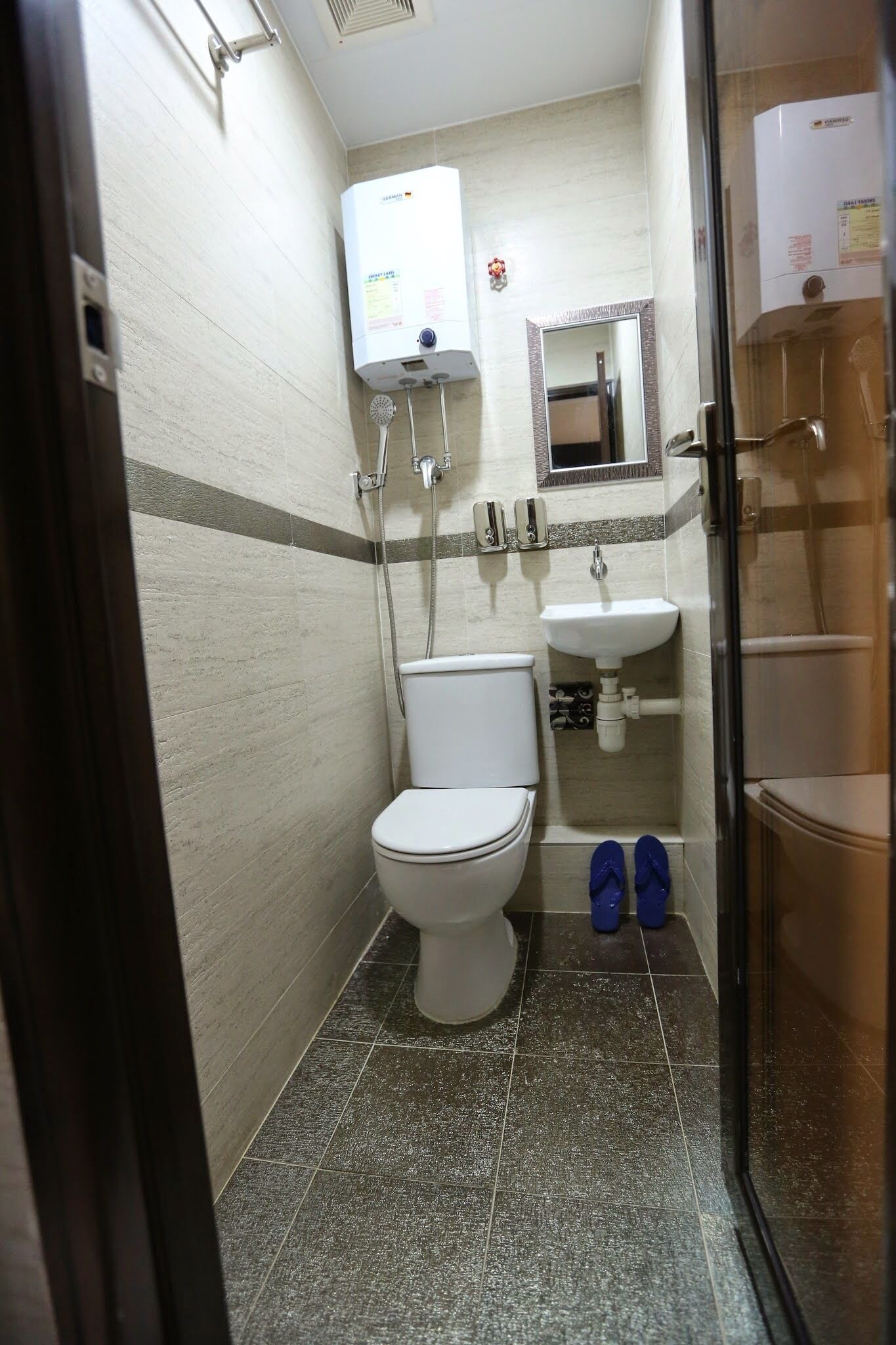 A small bathroom with a toilet, a sink, and a shower area.