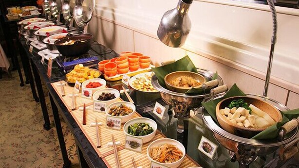 Een buffet met diverse gerechten en bestek.