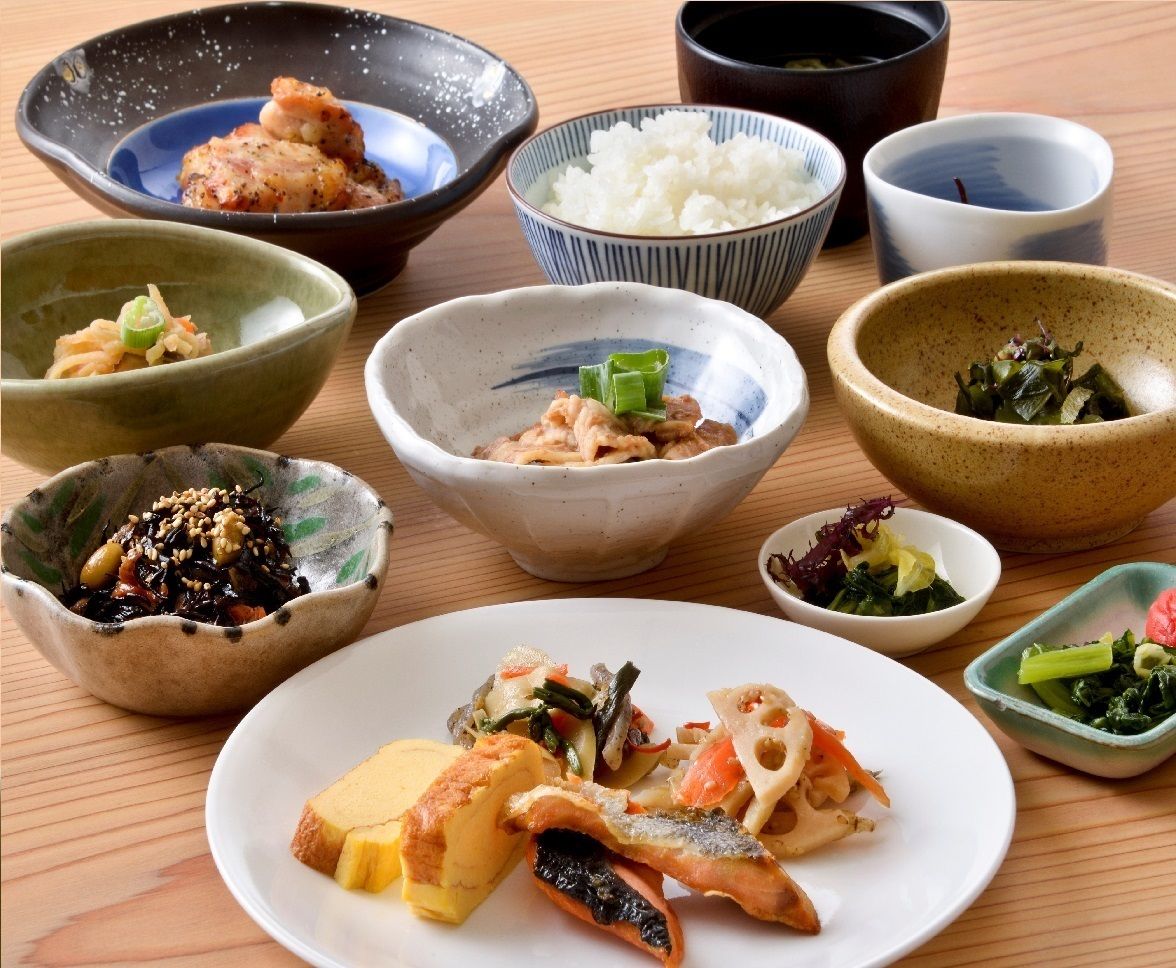 A variety of Japanese dishes including rice, seafood, and vegetables, served in traditional bowls and plates.