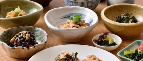 A variety of Japanese dishes including rice, seafood, and vegetables, served in traditional bowls and plates.