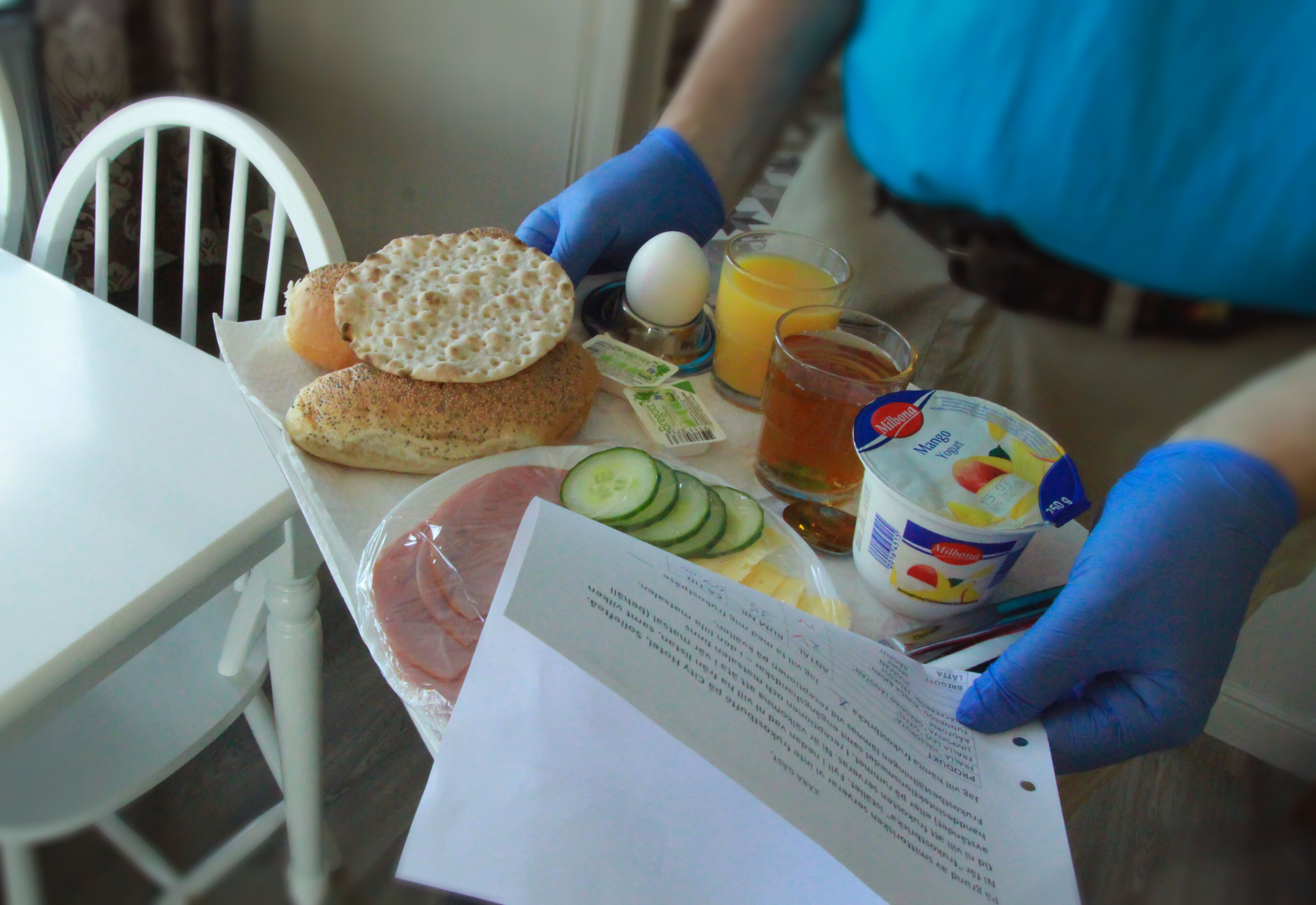 A breakfast tray with bread, egg, juice, and a milk carton.