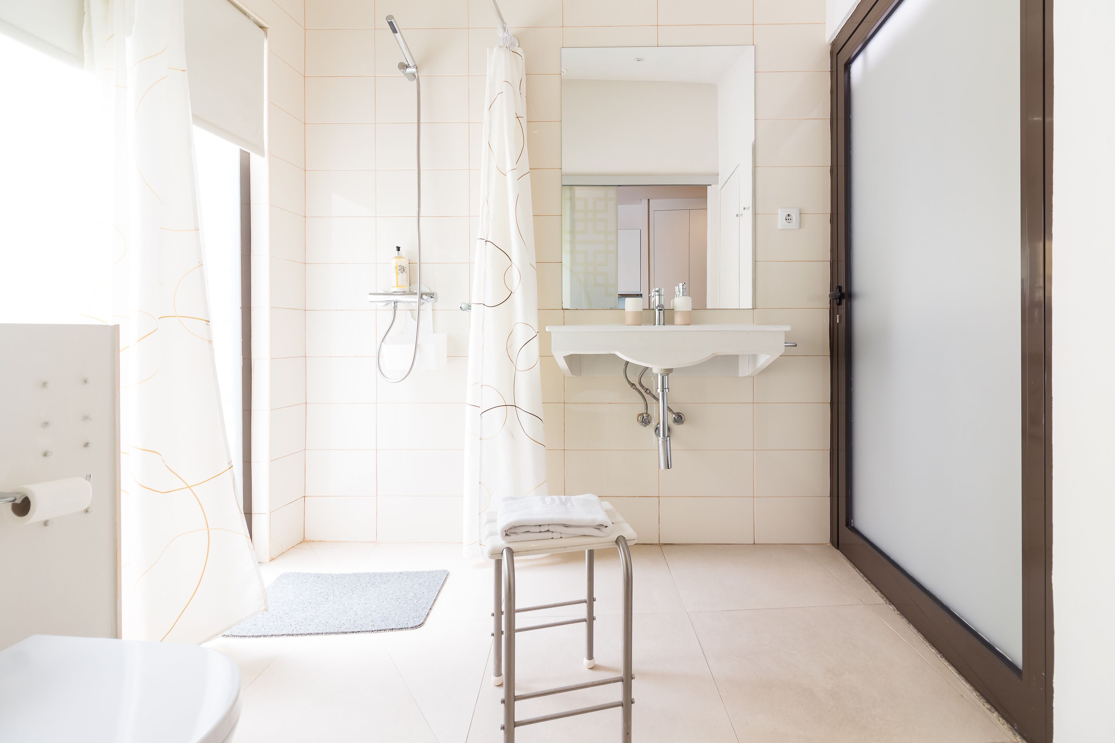 A modern bathroom with a shower, toilet, and sink.