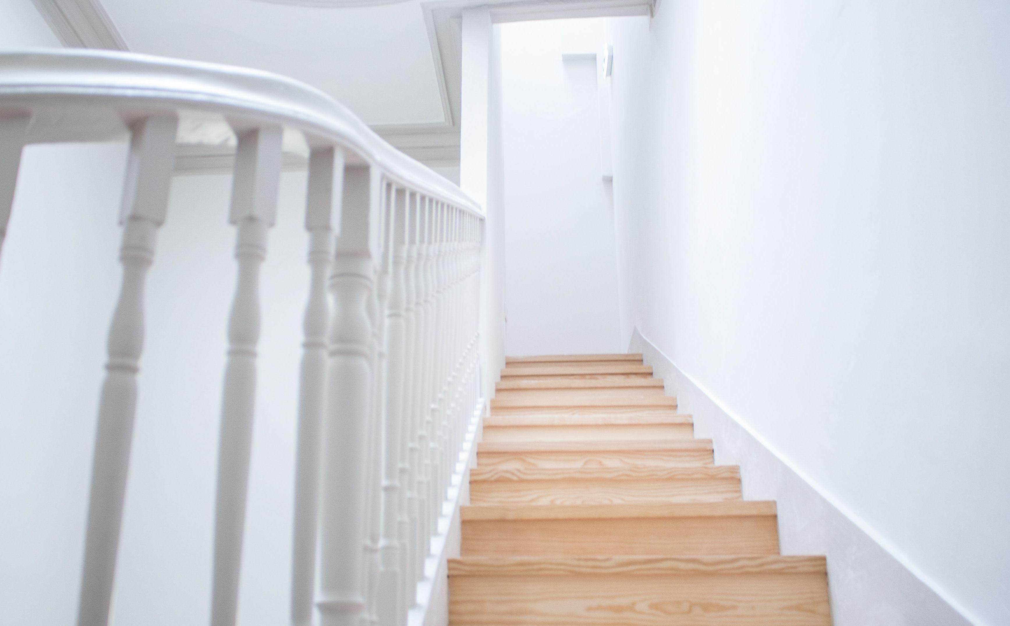 A staircase with wooden steps and white balusters.