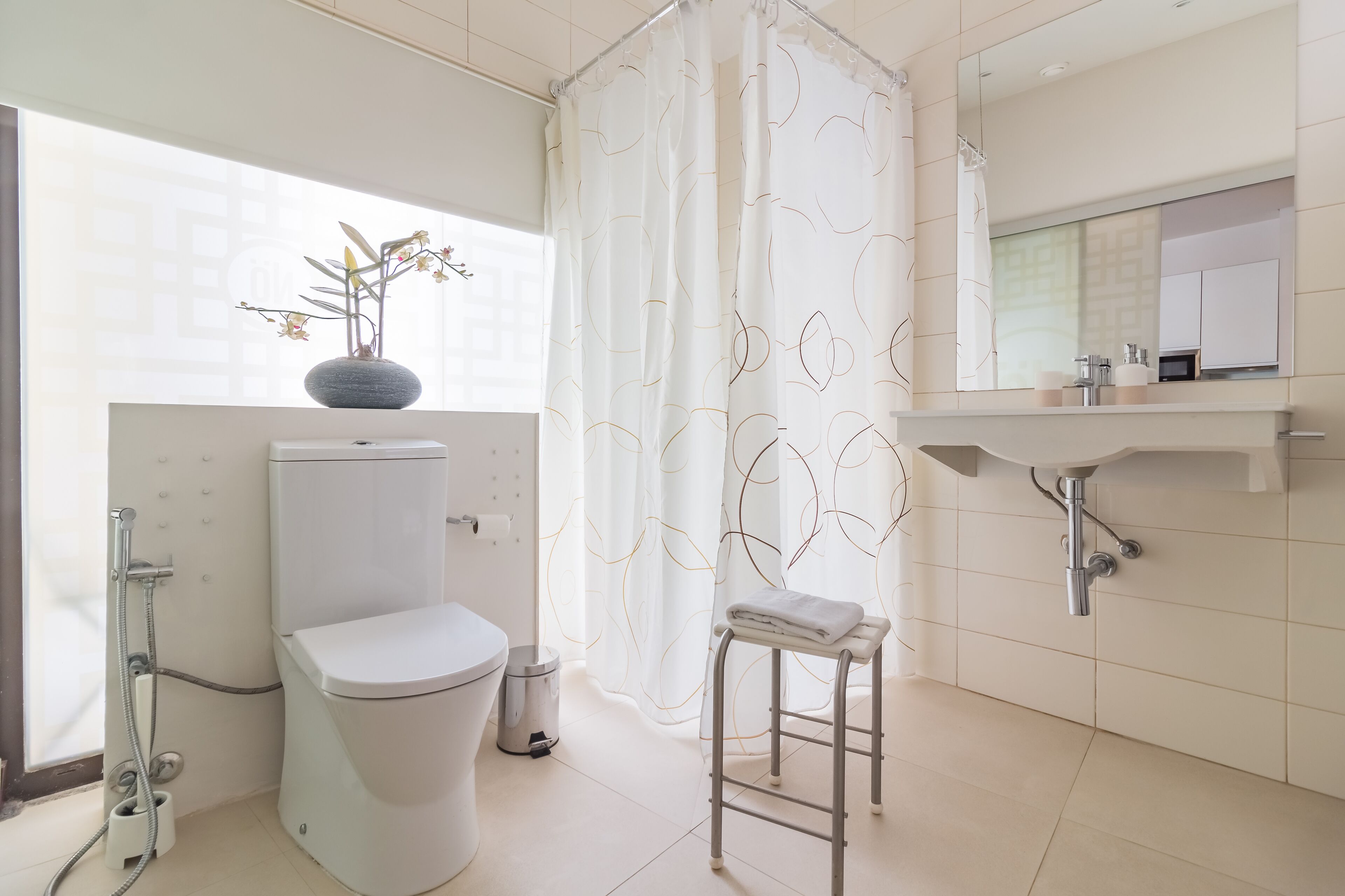A modern bathroom with a toilet, shower, and sink.