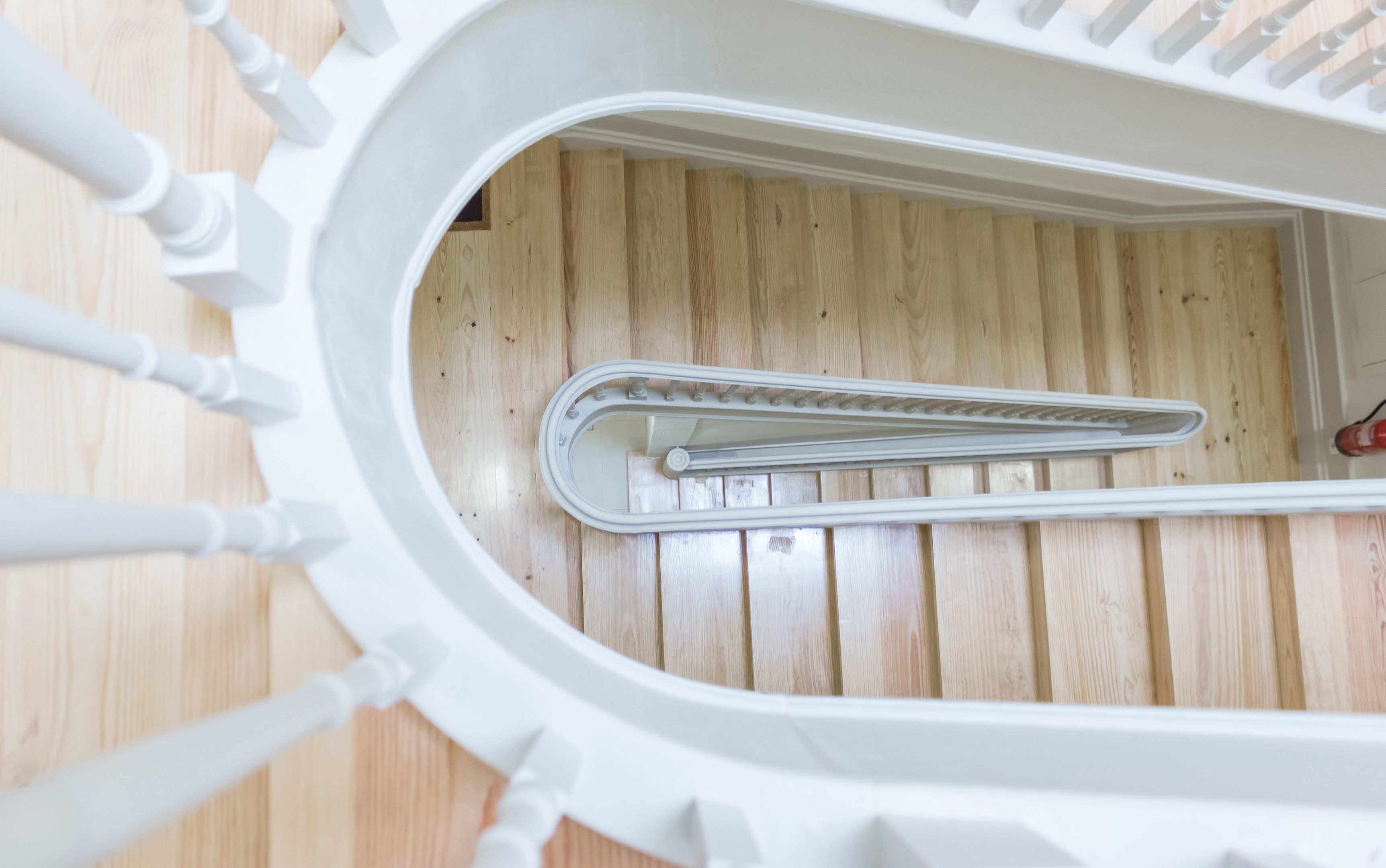 A white spiral staircase with a wooden floor.