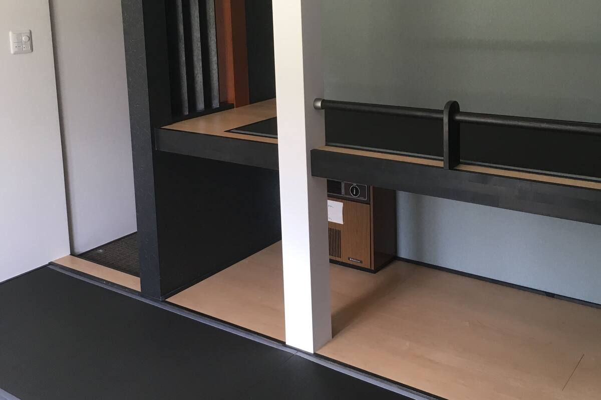 Une chambre moderne et minimaliste, équipée d’un lit superposé, d’un bureau escamotable et d’un petit meuble de rangement.