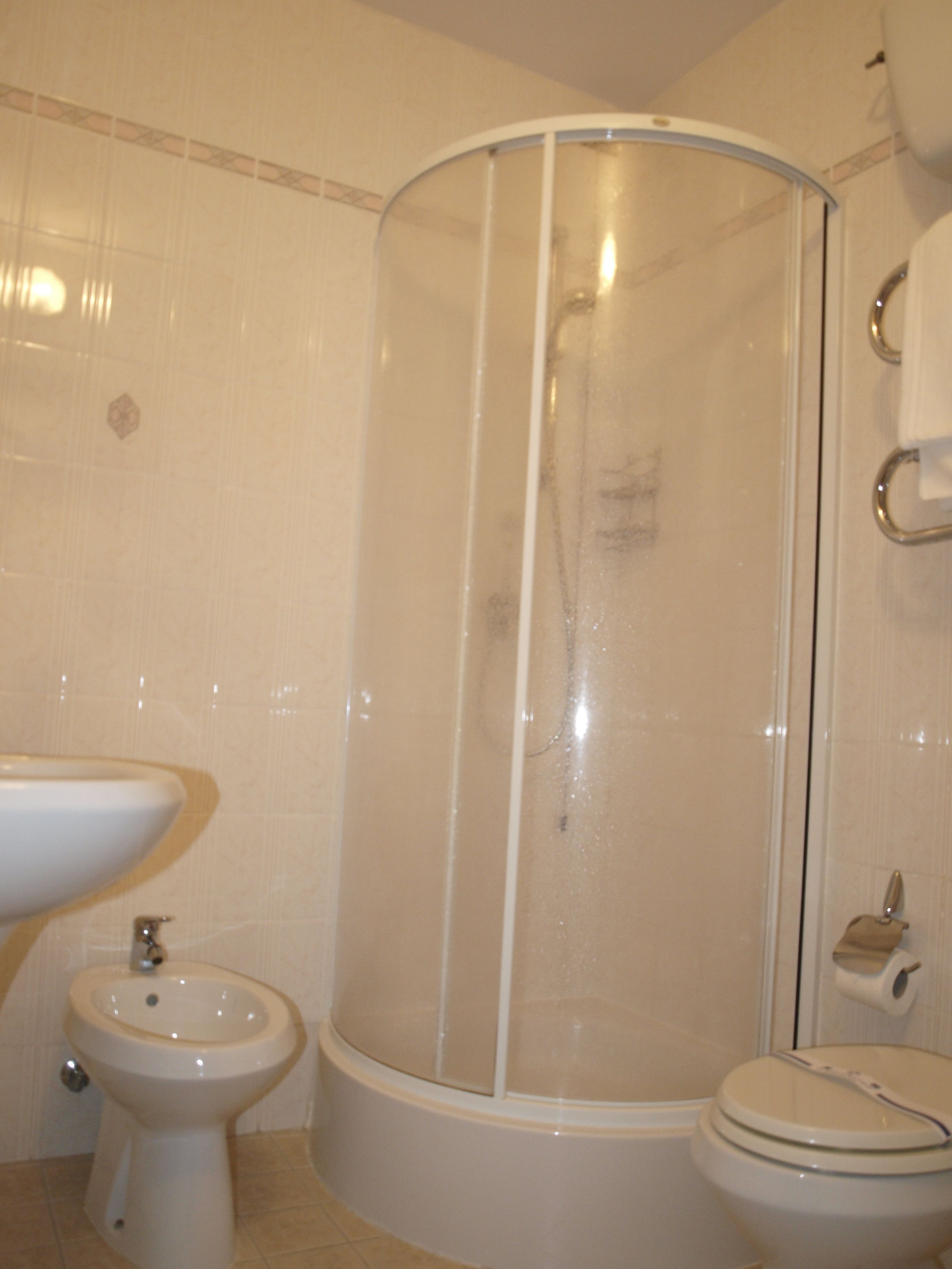 Un baño con cabina de ducha, lavabo e inodoro.