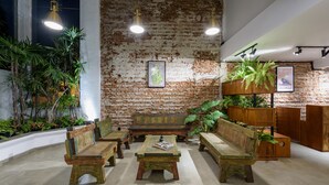 A rustic interior with exposed brick walls, wooden furniture, and hanging plants. - Fern Colombo (Colombo)
