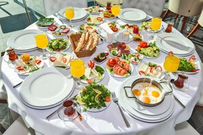 A breakfast buffet with various dishes, drinks, and bread on a round table. - Cevheri's Hotel (Istanbul)