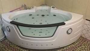 Un jacuzzi blanc doté d’un panneau en verre, installé devant un mur recouvert de carreaux.