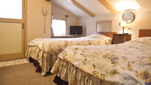 Une chambre avec deux lits, une télévision, un miroir et une fenêtre.