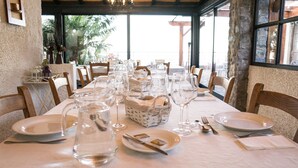 A dining table set for a meal with clear glassware, plates, and a basket. - Casa das Proteas (Santana)