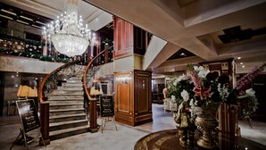 A grand lobby with a marble staircase, a chandelier, and a signboard. - Hotel Pamporovo (Chepelare)