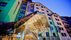 A hotel with a modern design, featuring a prominent entrance with a glass facade and a metal canopy. - Hotel Pamporovo (Chepelare)